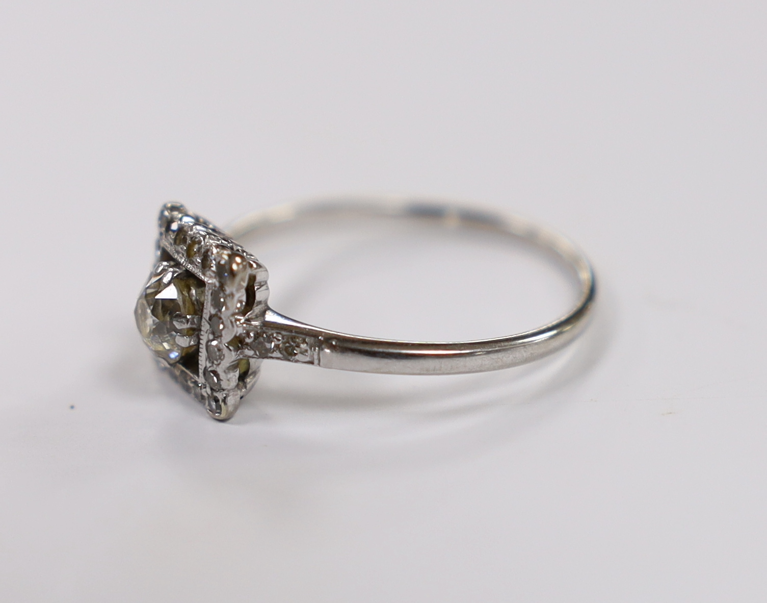 A 1940's 18ct white metal and single stone diamond ring, with diamond set square border and diamond set shoulders, size Q/R, gross weight 2.7 grams